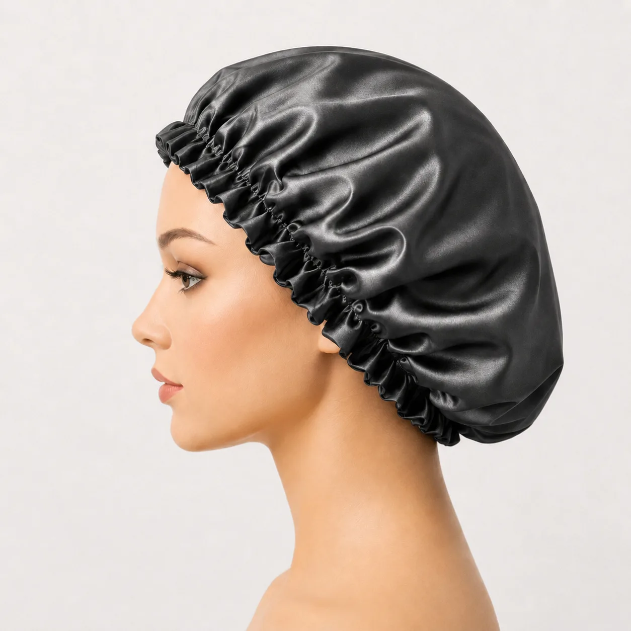  نمای نیم‌رخ کلاه خواب ساتن زغالی براق روی مانکن با نمایش حجم، چین‌های پارچه و کش دور کلاه